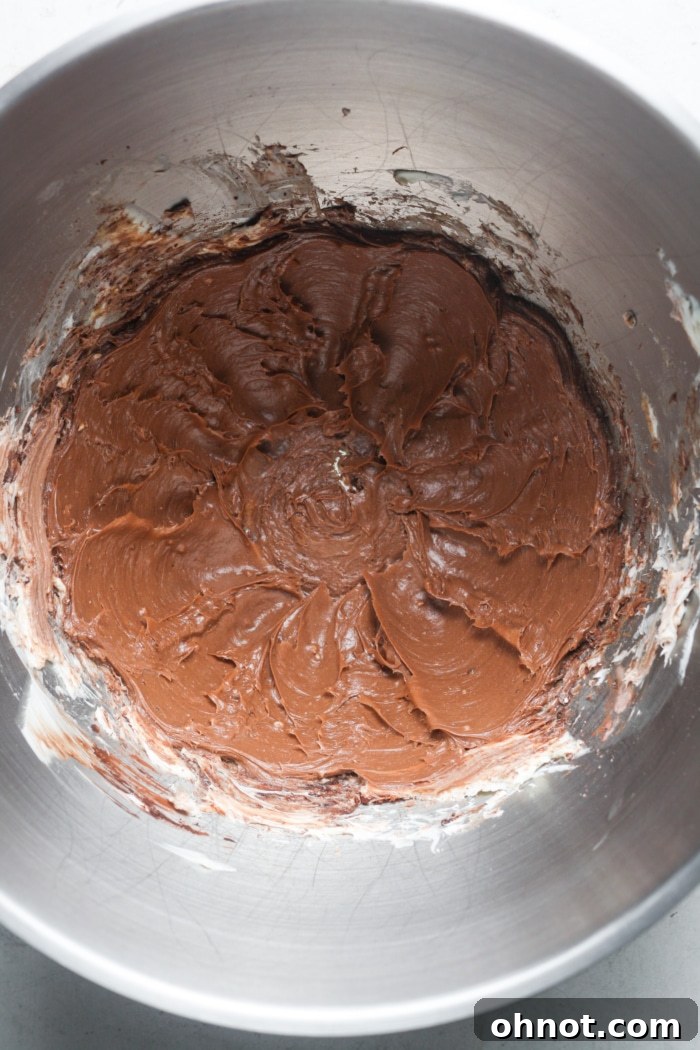Rich chocolate frosting in a mixing bowl, ready to be spread.