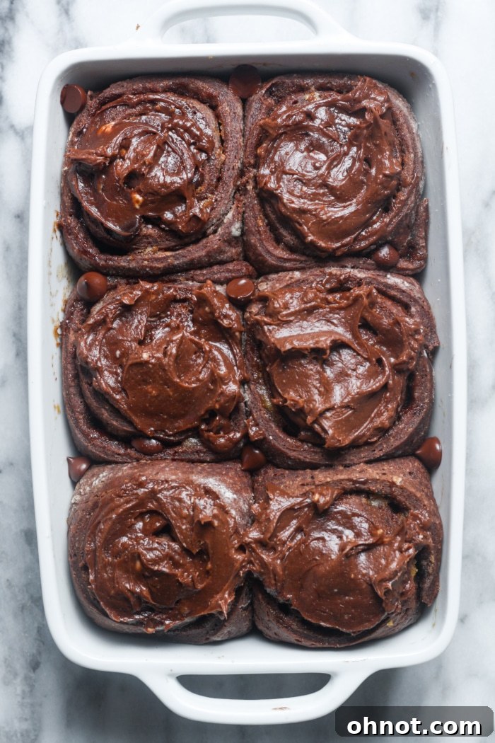 Frosted chocolate sweet rolls in a baking dish, ready to be served.
