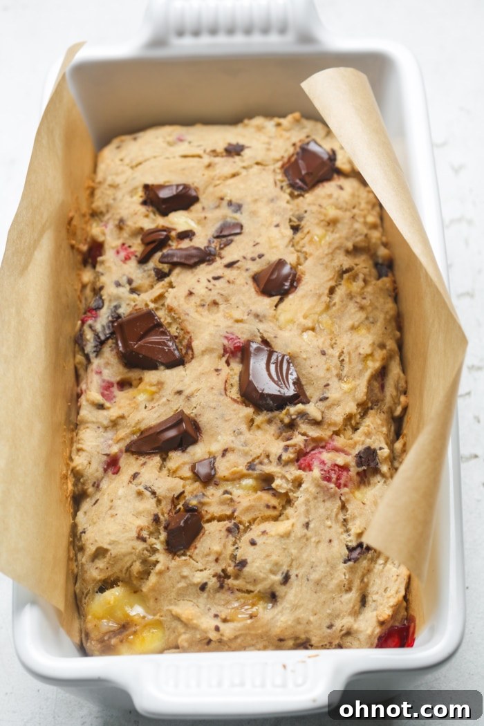A perfectly baked loaf of raspberry chocolate chip bread, golden brown on top.