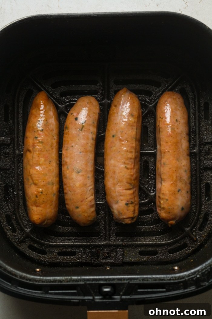 Raw Italian sausages placed in an air fryer basket, ready for cooking.