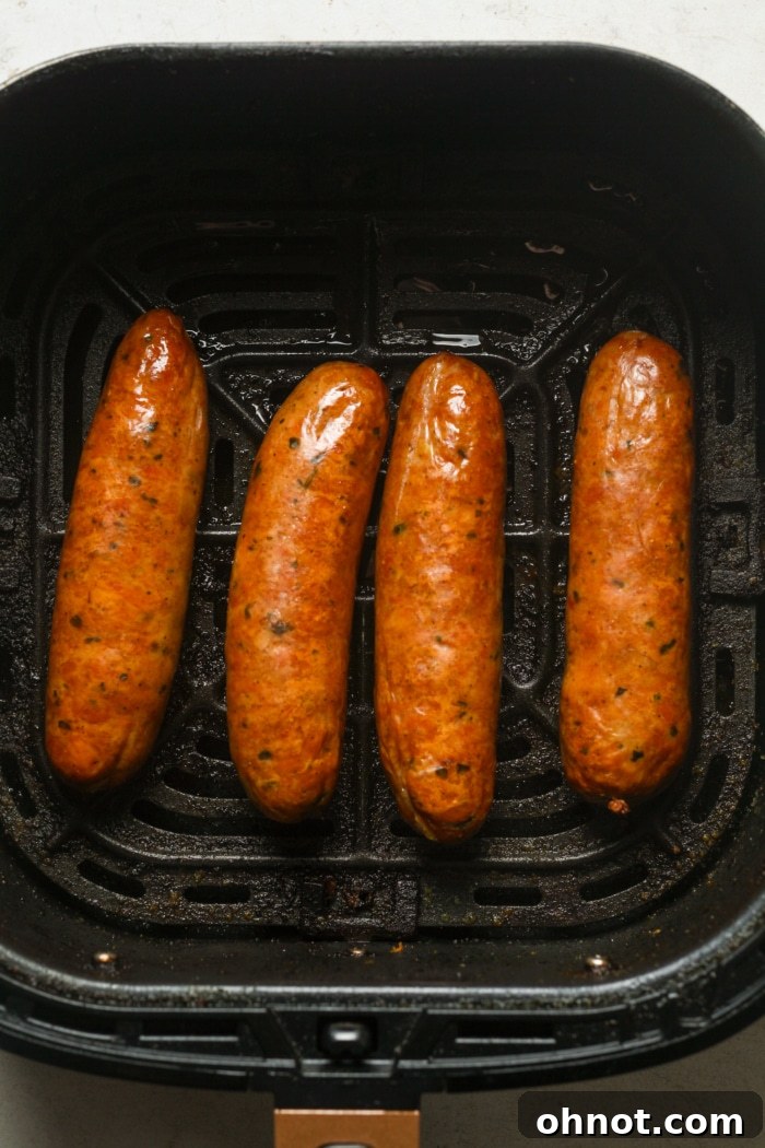 Air-fried Italian sausages halfway through cooking, showing a nice brown color.