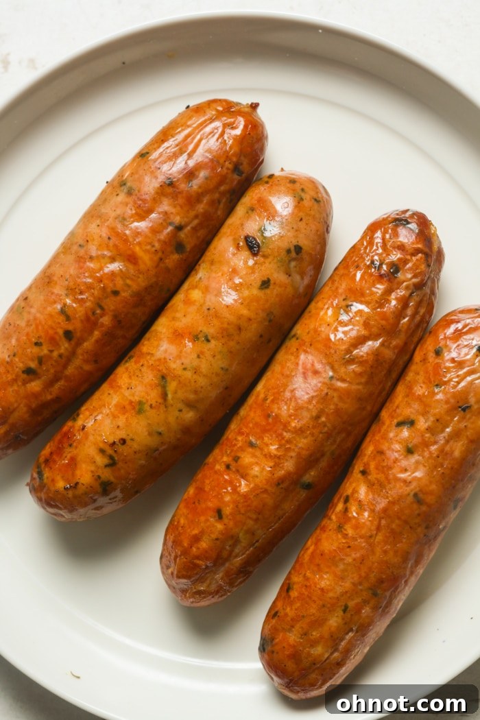 Cooked Italian sausages arranged on a plate with fresh herbs as garnish.