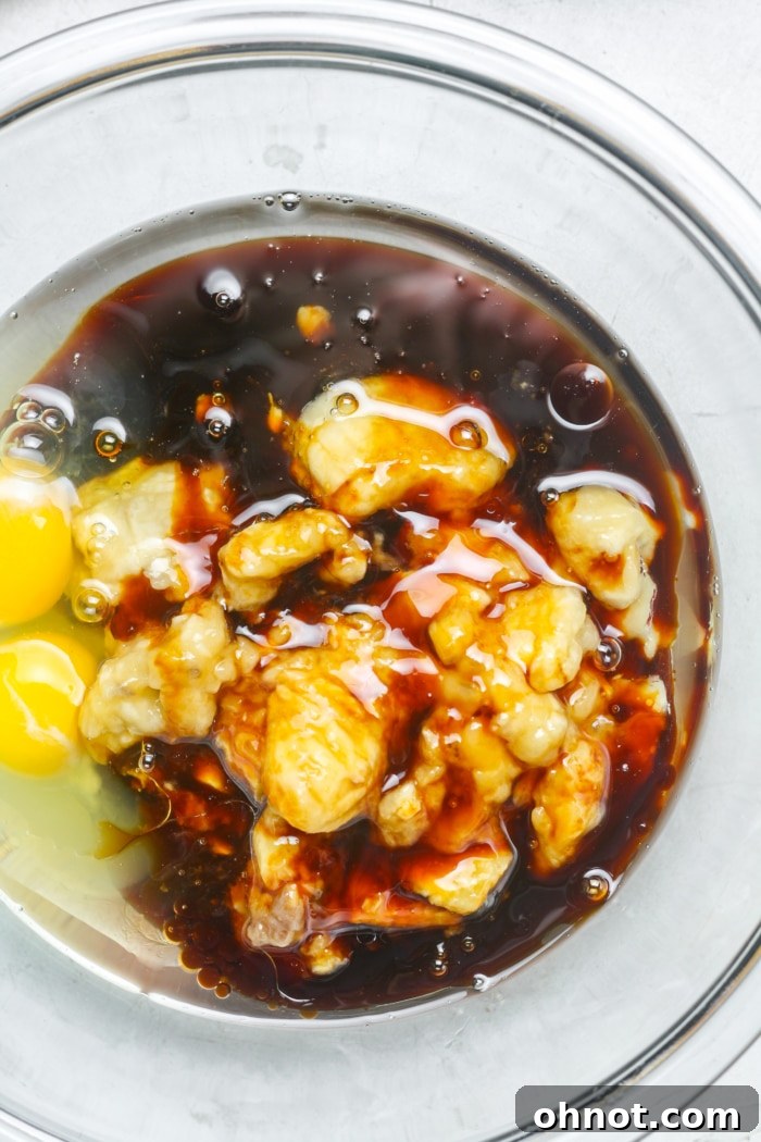 Mashed bananas, eggs, and maple syrup in a mixing bowl.