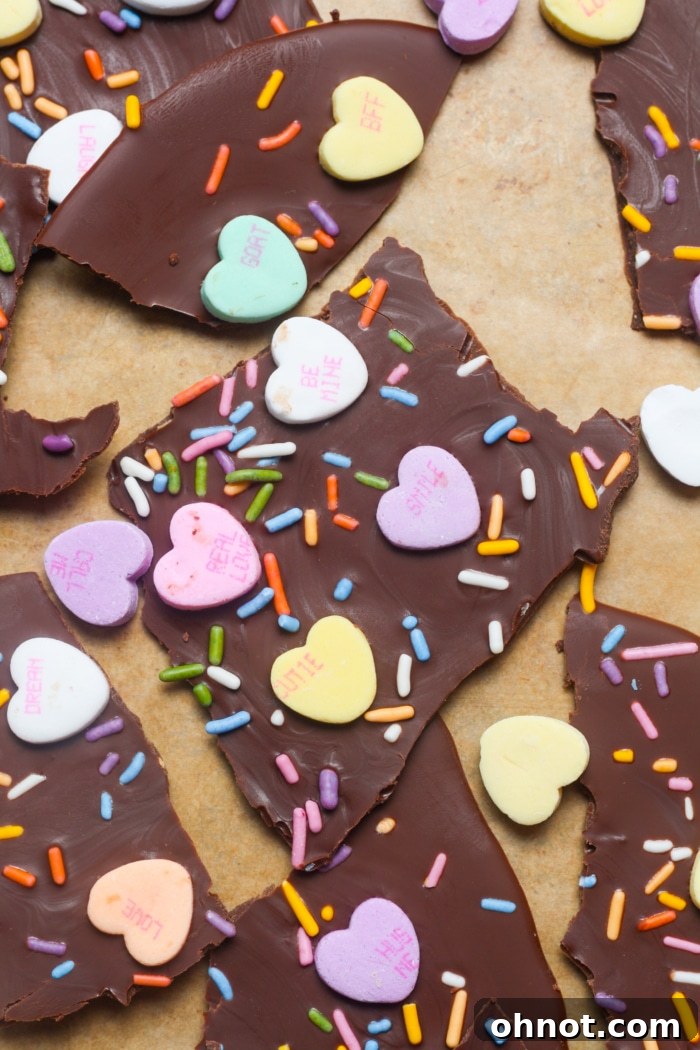 Close-up of a delightful piece of chocolate Valentine's candy, adorned with conversation hearts and sprinkles, showcasing its festive appeal.