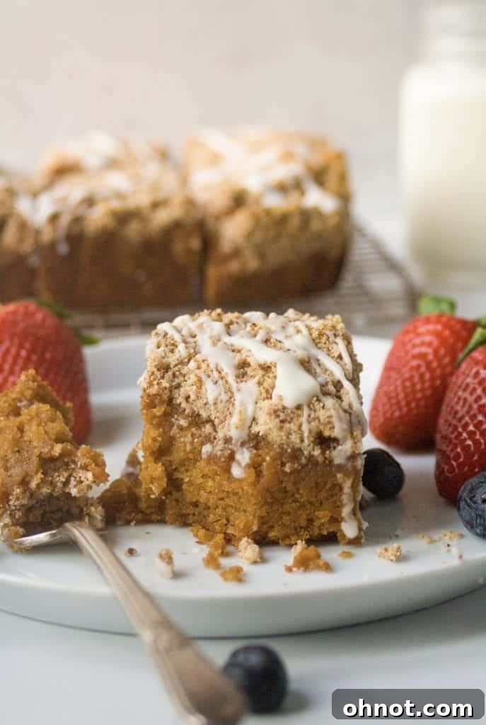 Paleo cinnamon coffee cake adorned with fresh fruit, showcasing its delicious texture