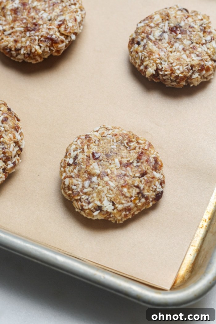 Healthy no-bake coconut cookie discs formed on parchment paper.