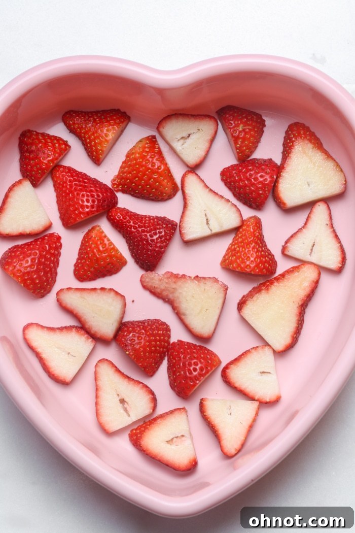 Heart-shaped pan lined with sliced strawberries.