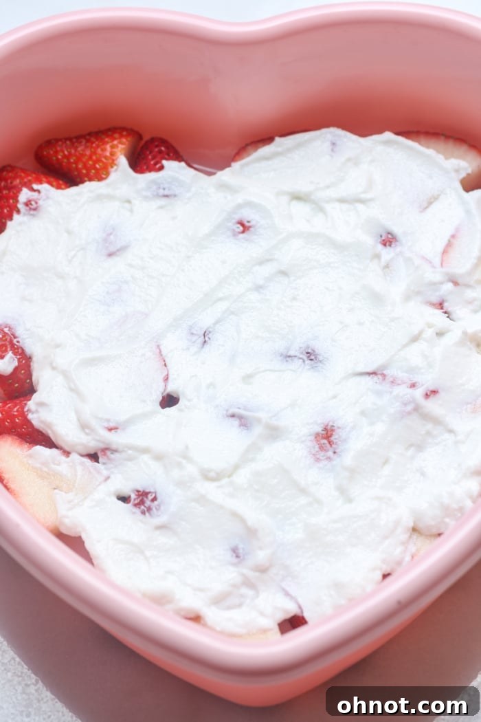 Yogurt spread over berries in a pan, ready for freezing.