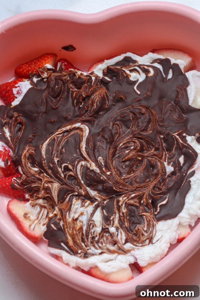Melted chocolate drizzled and swirled over yogurt and strawberries.