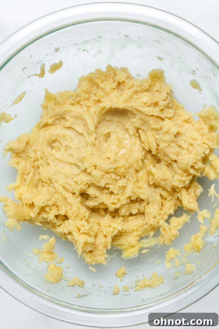 Soft yellow cookie batter in a mixing bowl.