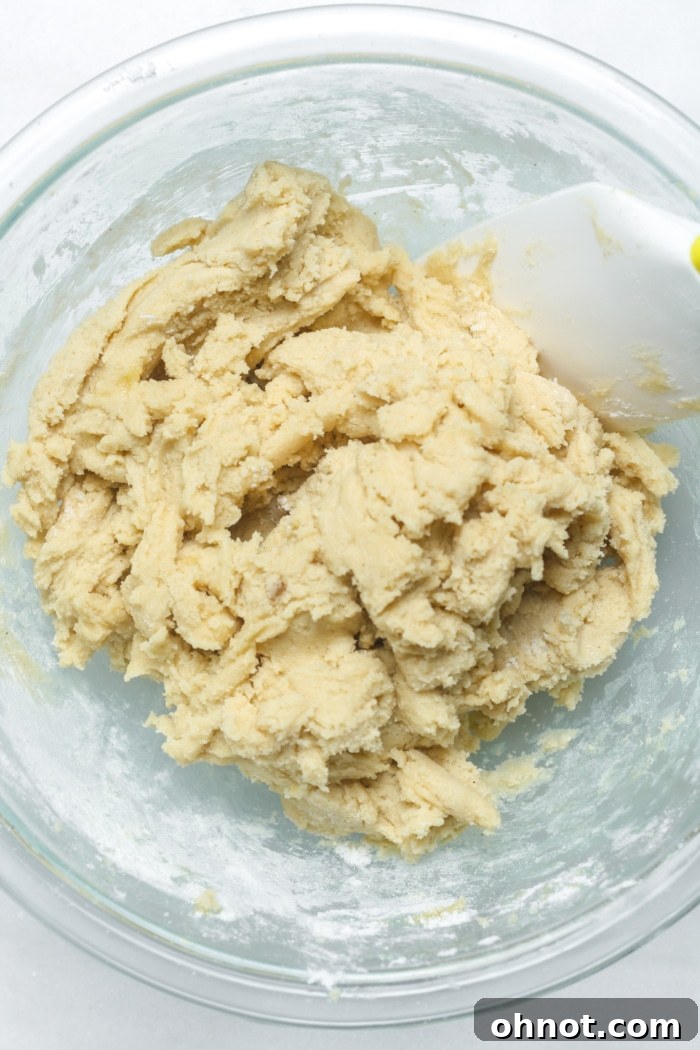 Thick, light-colored cookie dough in a mixing bowl.