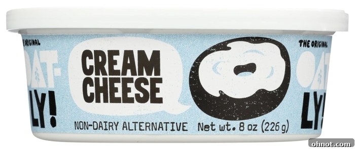 A tub of Oatly oat milk-based cream cheese dairy alternative, highlighting its smooth texture and plant-based origin.