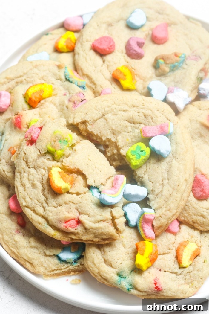 A broken Lucky Charms cookie, revealing its soft, chewy interior and vibrant marshmallows.