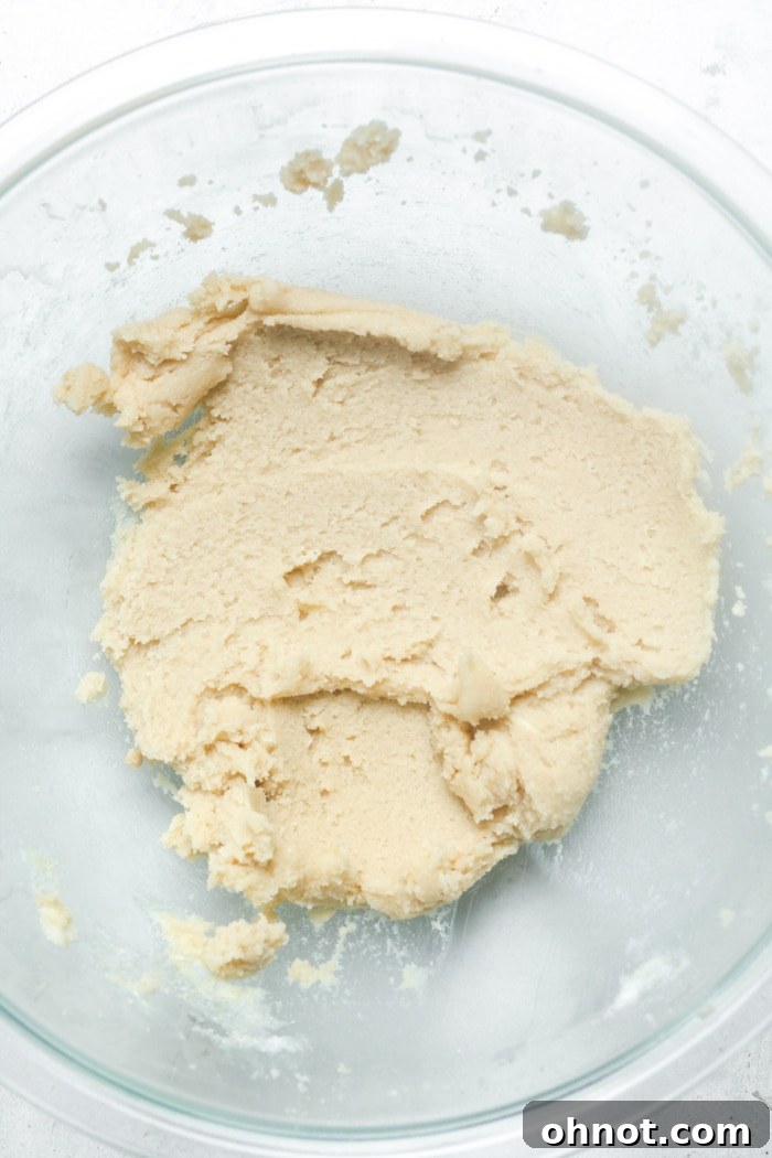 Creamy mixture of butter and sugars in a stand mixer bowl.