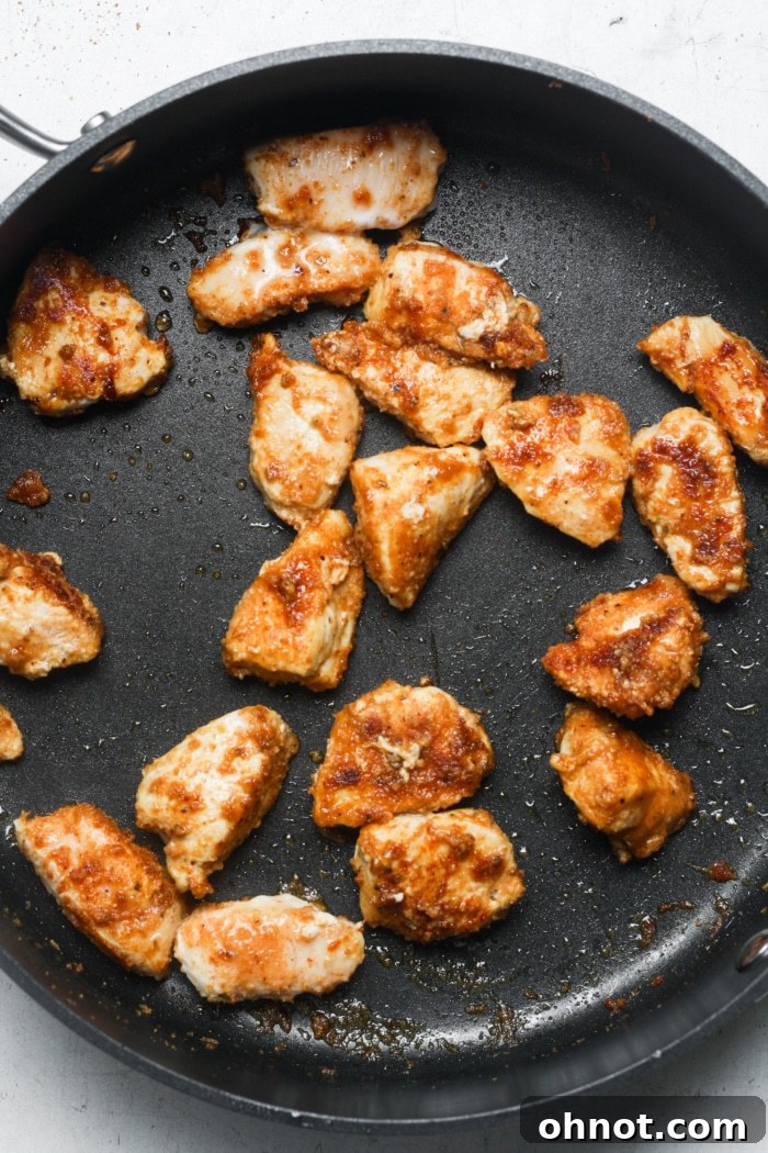 Sizzling fajita chicken cooking in the pan, releasing aromatic spices.