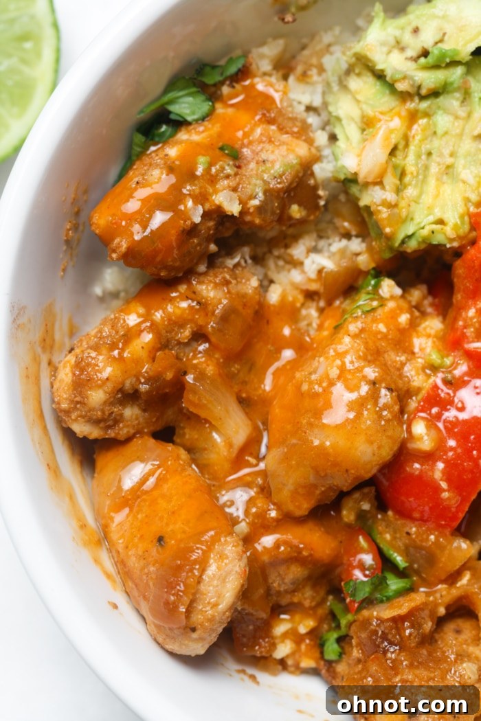 A close-up of a spicy chicken fajita bowl with vibrant ingredients.