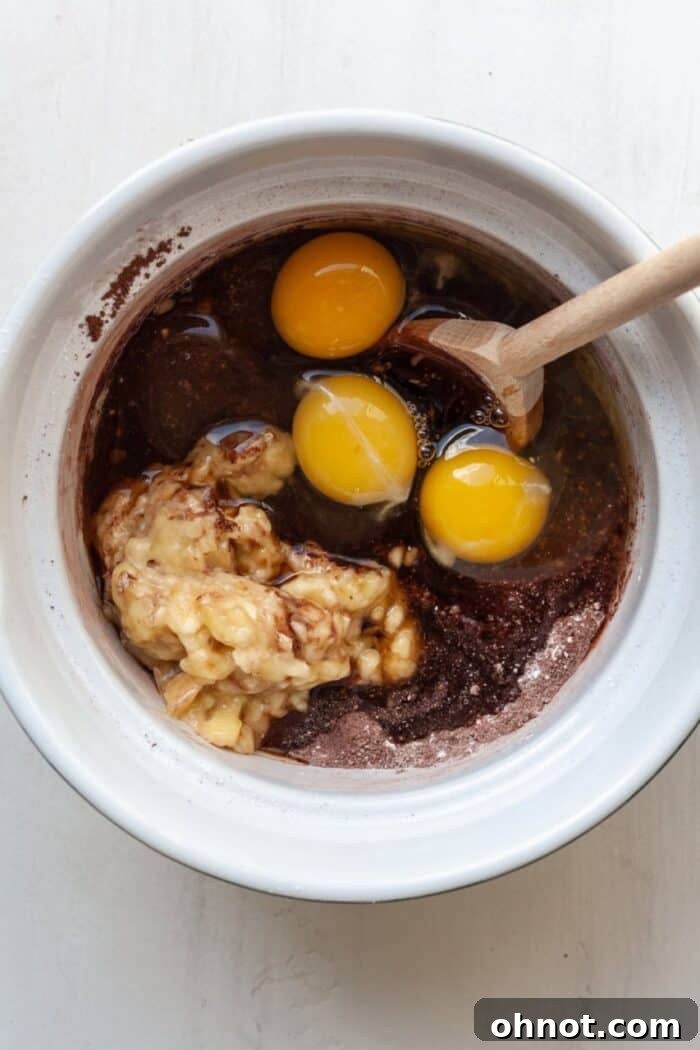 Wet ingredients added to the dry mixture in a large mixing bowl