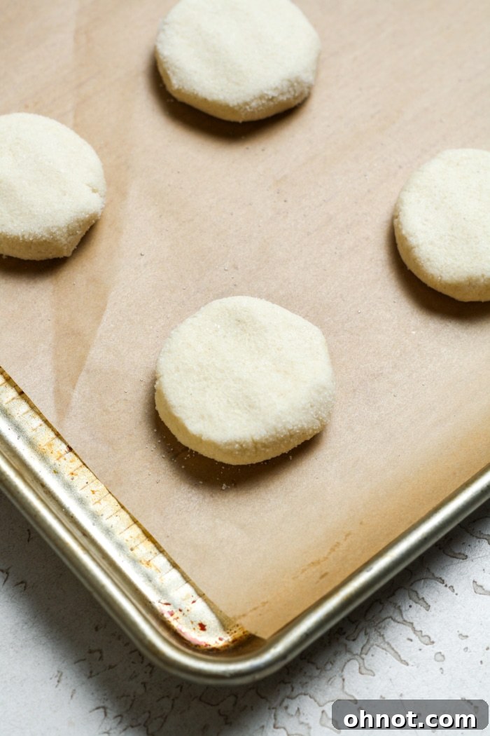 Gently flattened cookie dough balls on a baking sheet.
