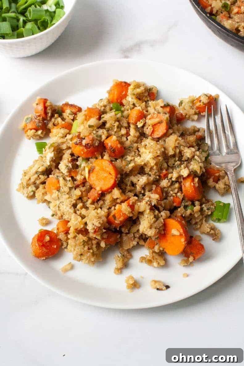 A serving of Whole30 Cauliflower Fried Rice in a bowl with a fork