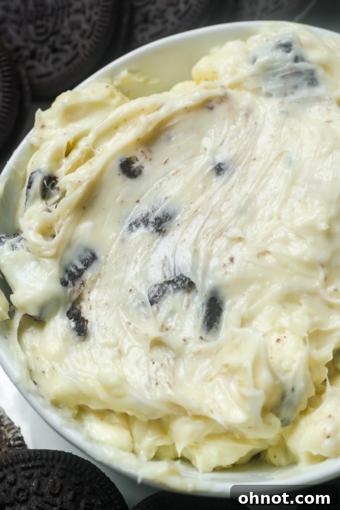 Close-up of a bowl filled with creamy cookies and cream sauce, showcasing the rich texture and cookie pieces.