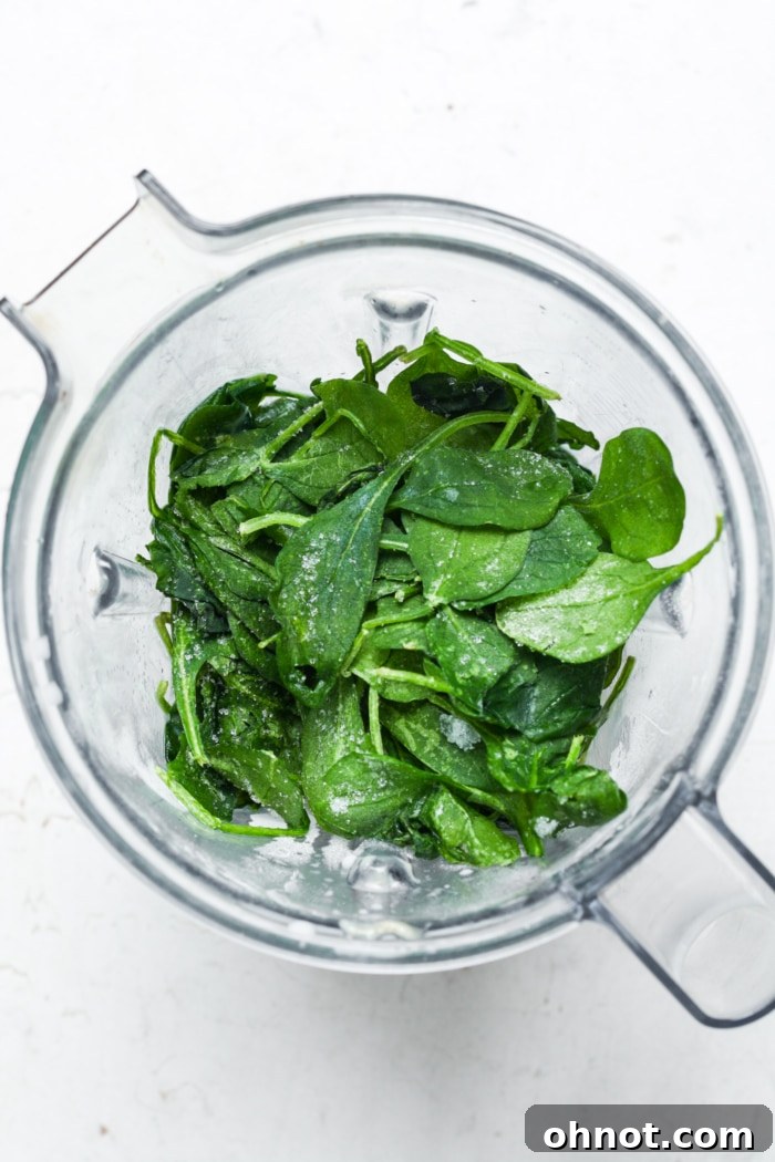 Frozen spinach, banana, and milk added to a blender for a shamrock shake.
