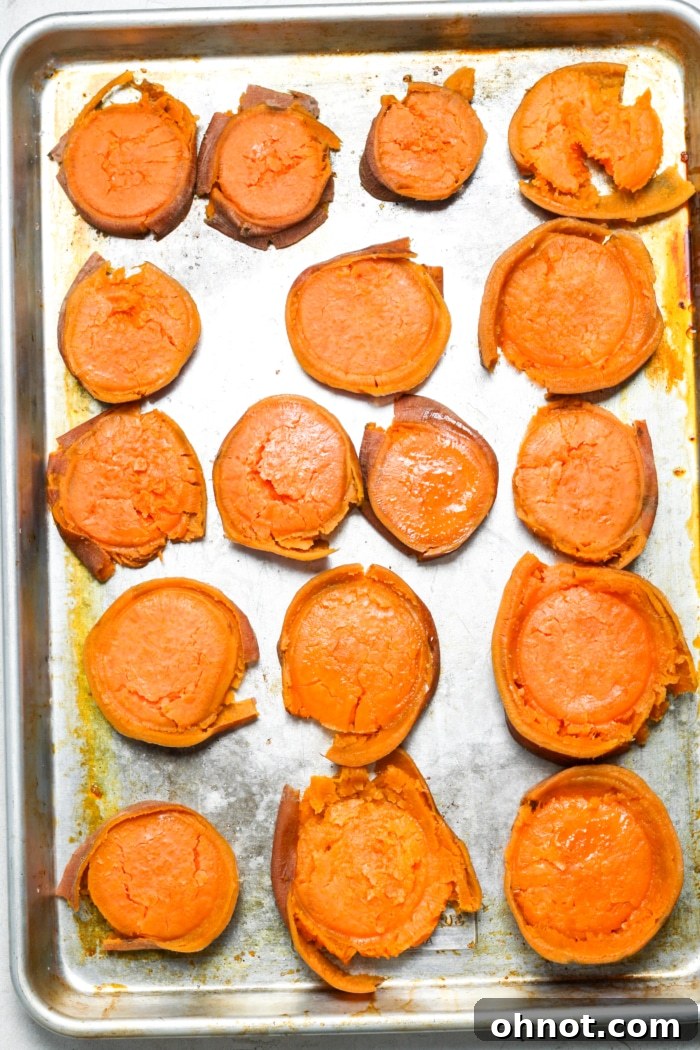 Sweet potato rounds being smashed with the bottom of a glass for a crispy texture.