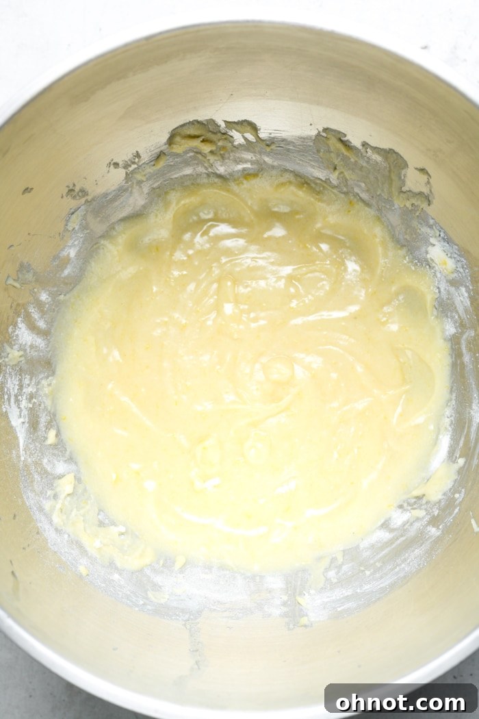 Gooey yellow brownie batter in a mixing bowl after dry ingredients have been folded in.