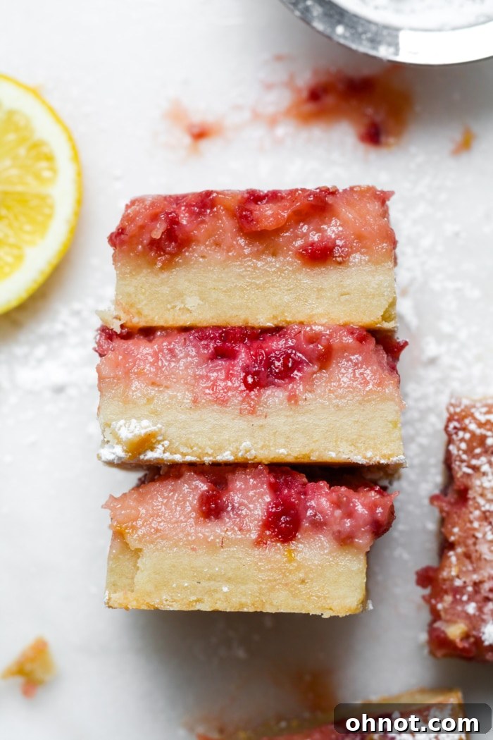 Stack of lemon raspberry bars on a plate.