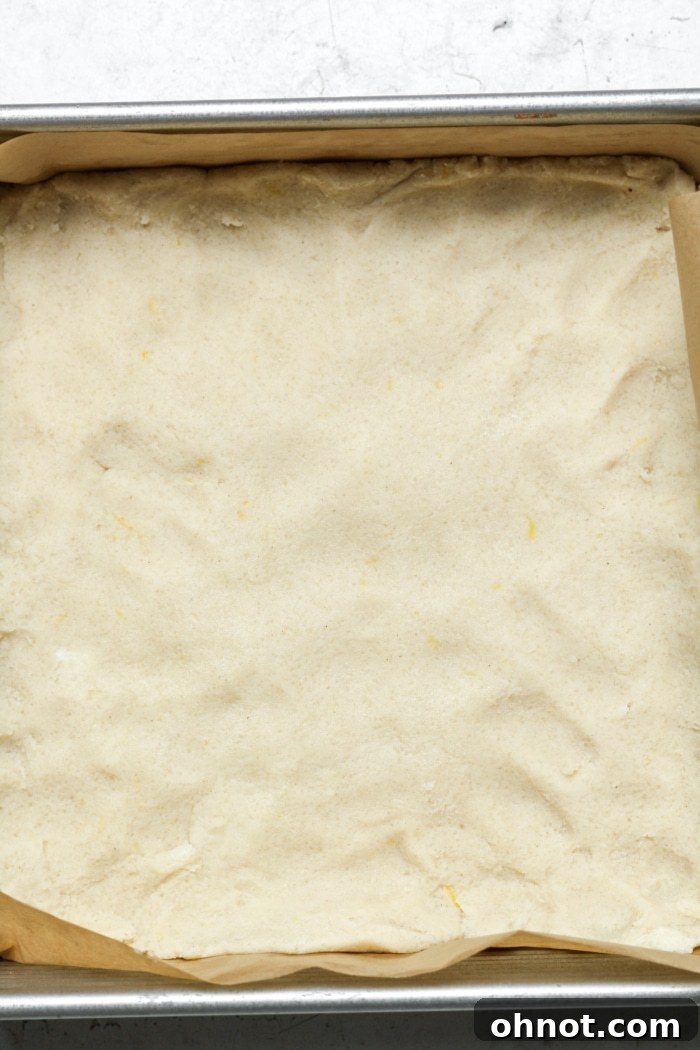 Square pan with unbaked shortbread dough pressed in.