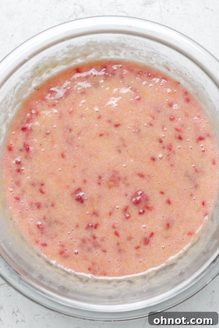 Creamy pink raspberry lemon batter in a bowl.