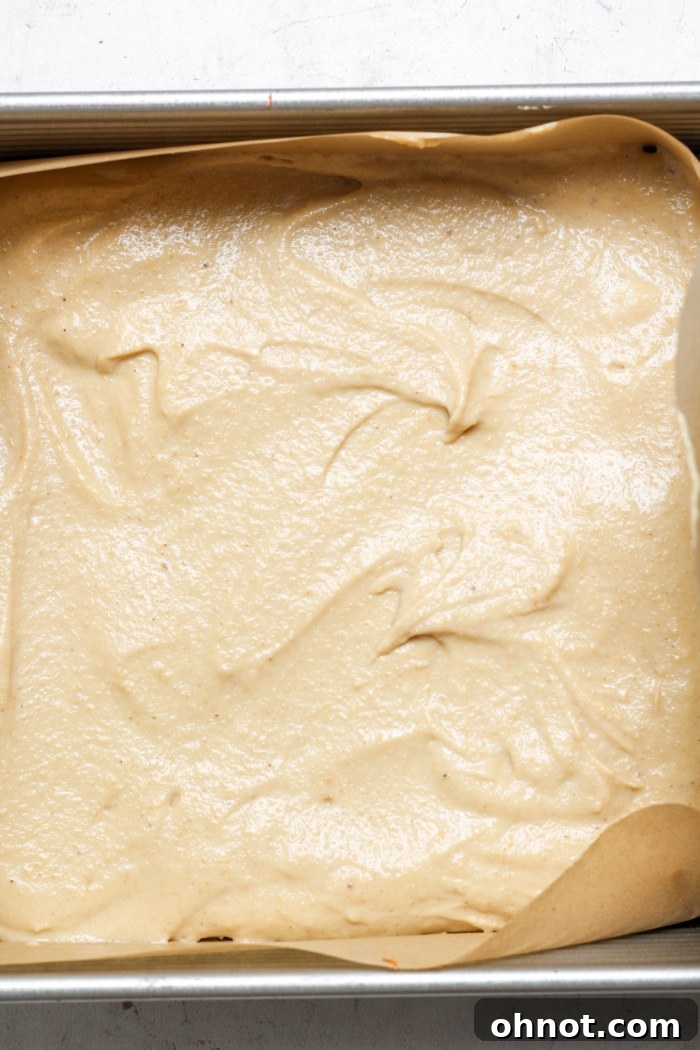 Creamy beige cheesecake mixture poured over the crust in a pan.