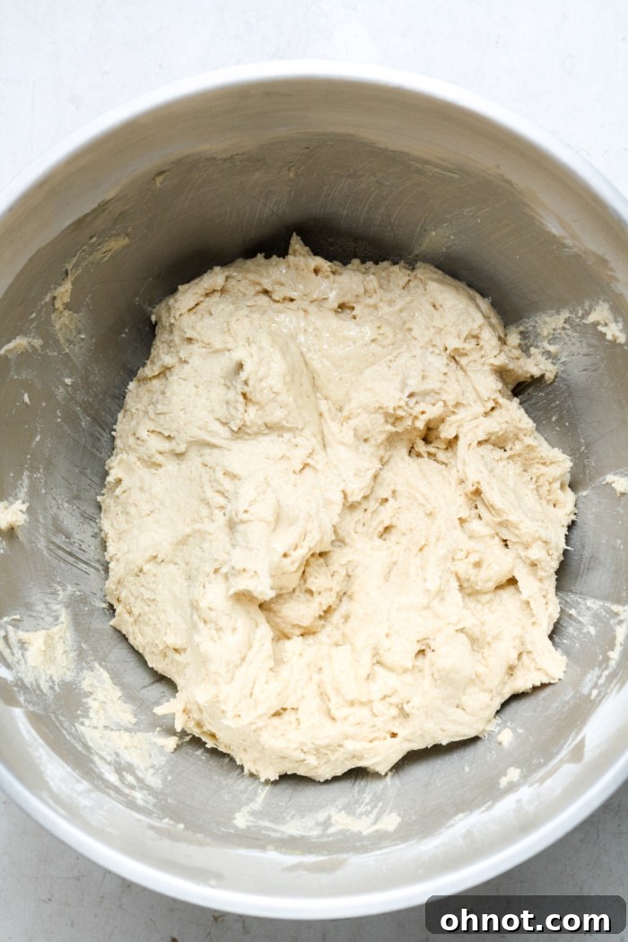 Sticky gluten-free bread dough in a stand mixer bowl.