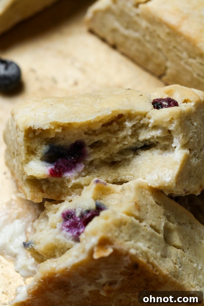 Close-up of a soft, flaky gluten-free scone with blueberries.
