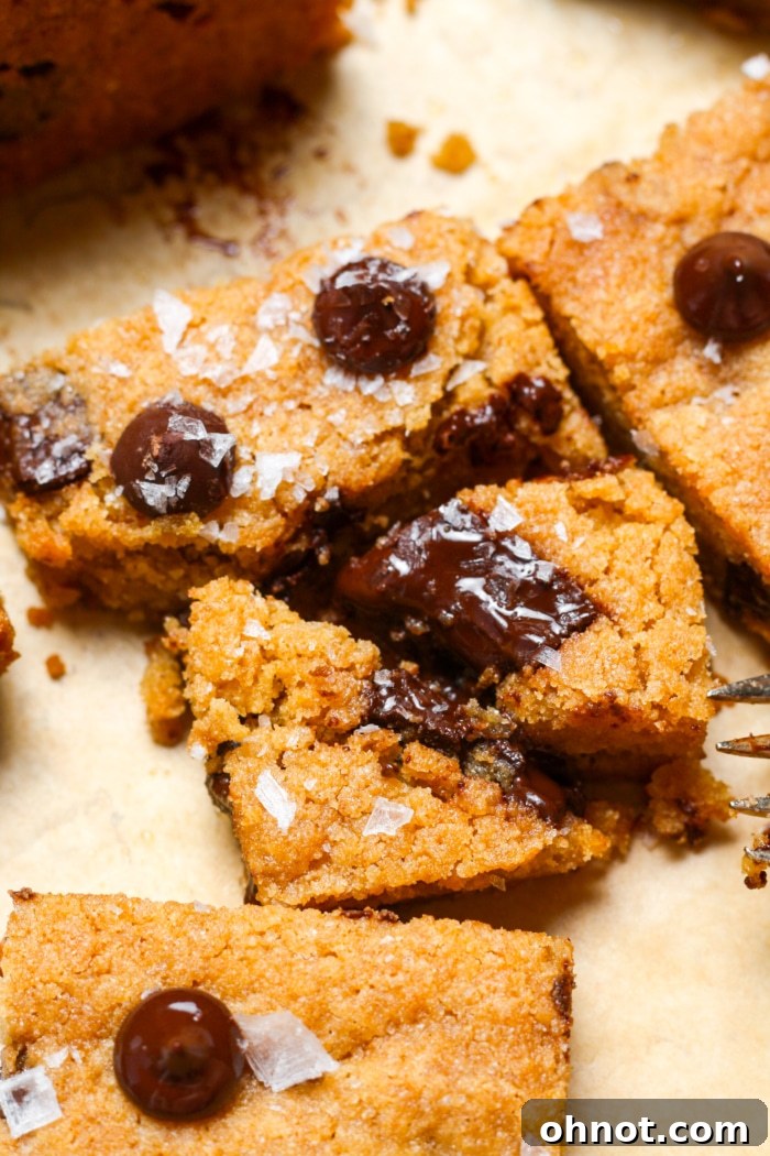 A stack of gooey dessert squares with visible chocolate chips and a sprinkling of sea salt.