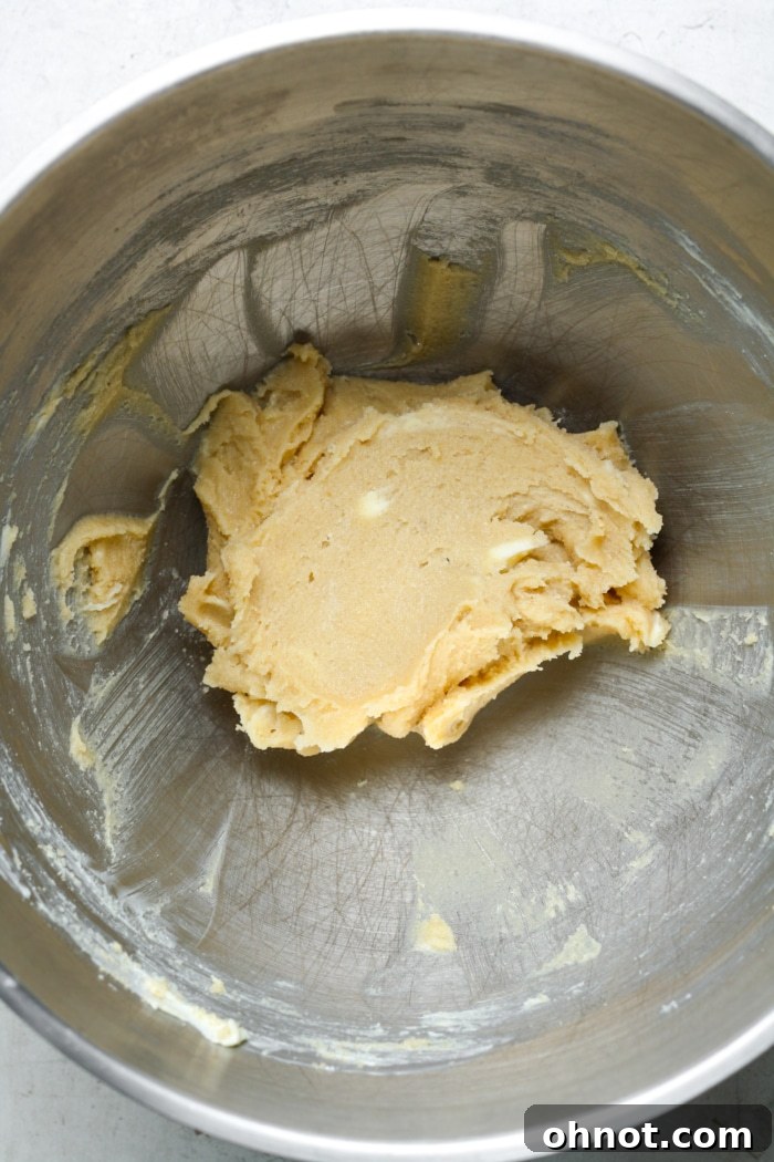 Creamy, pale yellow butter, granulated sugar, and brown sugar blended together in a stand mixer bowl.