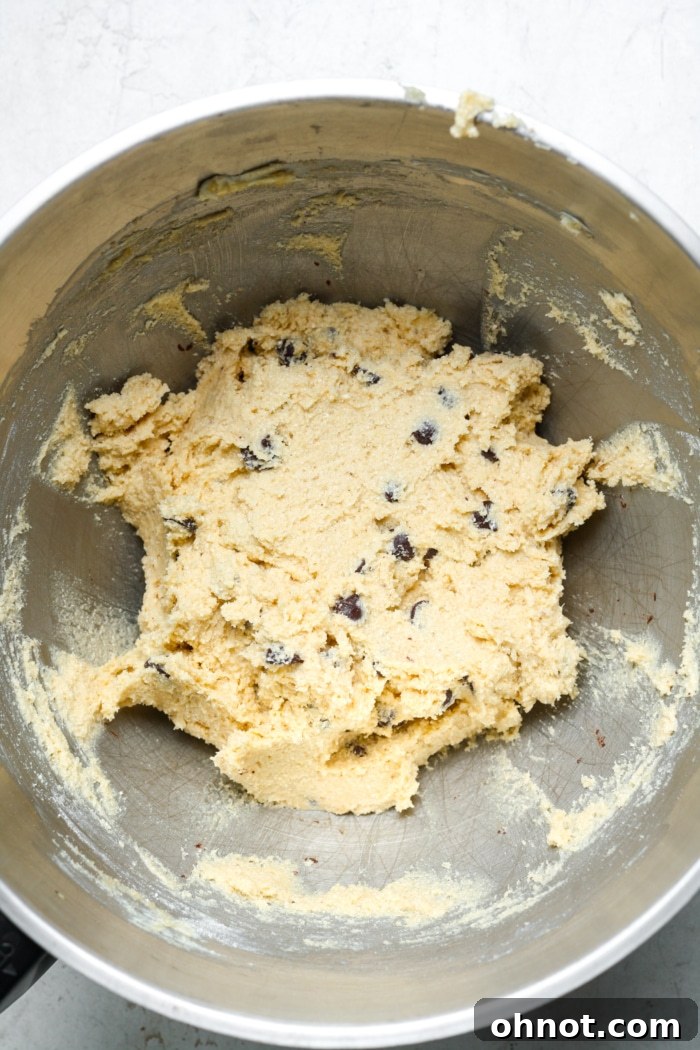 Rich chocolate chip cookie pie dough with dark chocolate chips folded in, ready for baking.