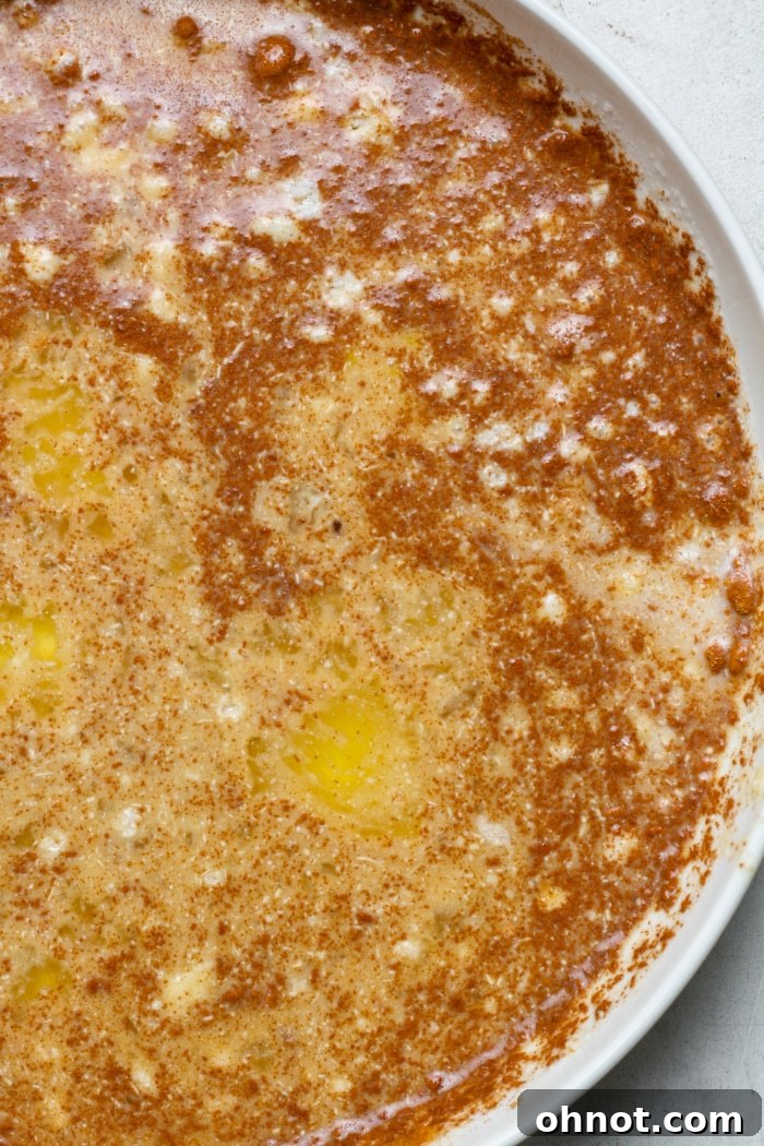 Milk, eggs, and cinnamon being whisked together in a clear bowl for French toast batter.