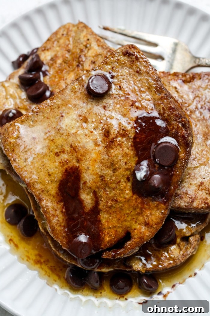 Gluten-free French toast topped with melted chocolate chips and a generous drizzle of maple syrup.