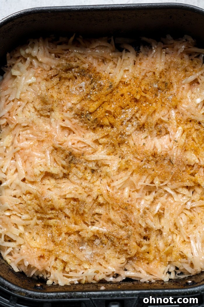 Close-up of shredded potatoes seasoned and ready for air frying.