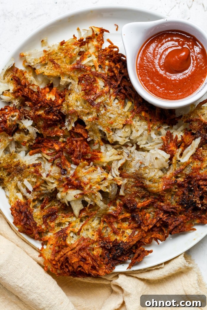 A plate of perfectly golden and crispy air fryer hash browns.