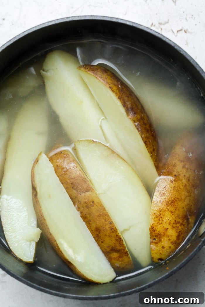 Boiled Russet potato wedges, ready for seasoning and air frying.