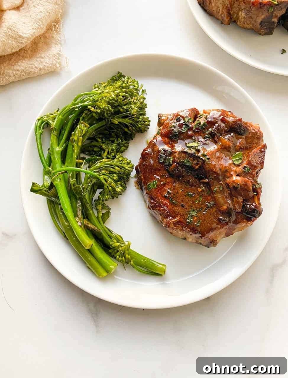 Plated balsamic pork chops with sauce and fresh herbs