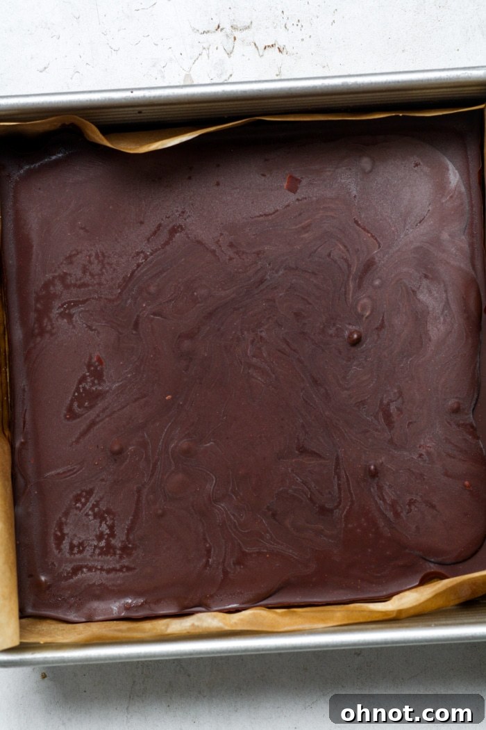 Hardened chocolate topping in the pan, ready for slicing.