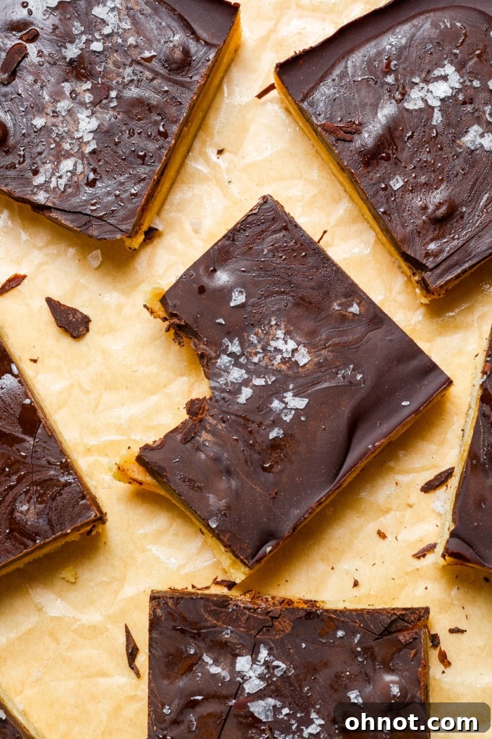 A close-up of a Millionaire Bar with a bite taken out, showing the three distinct layers.