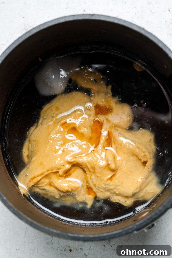 Peanut butter and coconut oil melting together in a small saucepan.