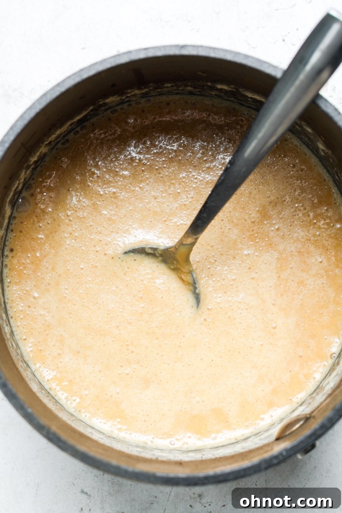 Smooth and creamy peanut butter caramel mixture in a saucepan.