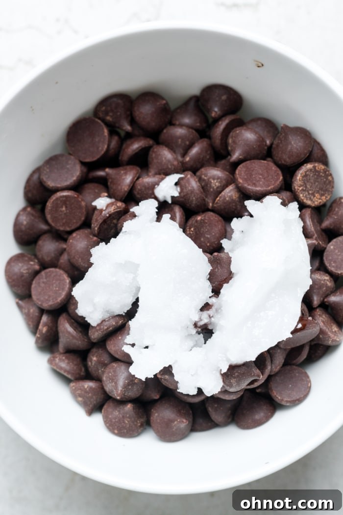 Dark chocolate chips and coconut oil in a microwave-safe bowl.