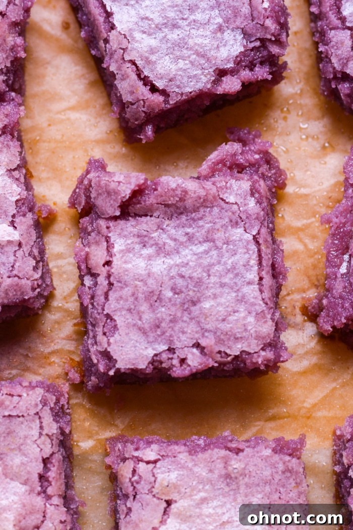 Fudgy purple ube brownies with a crackly top, sliced and ready to eat.