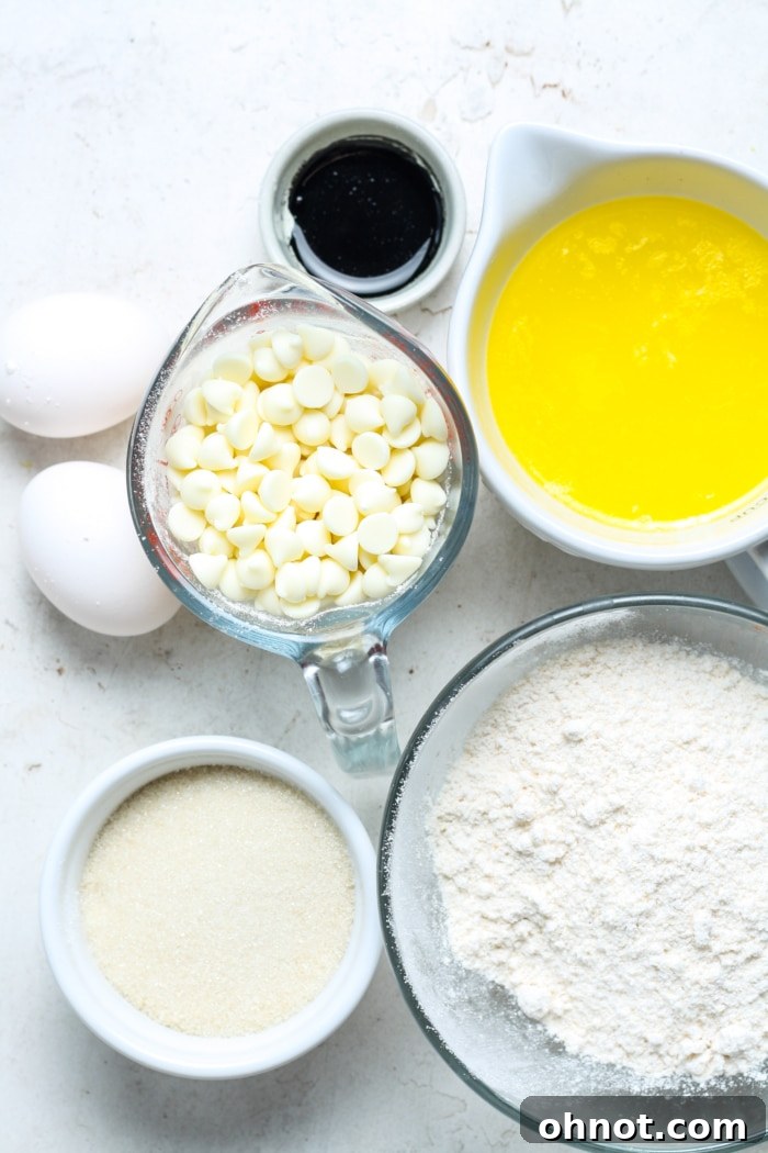 Collection of fresh ingredients for ube brownies: butter, white chocolate chips, sugar, ube extract, eggs, and flour.