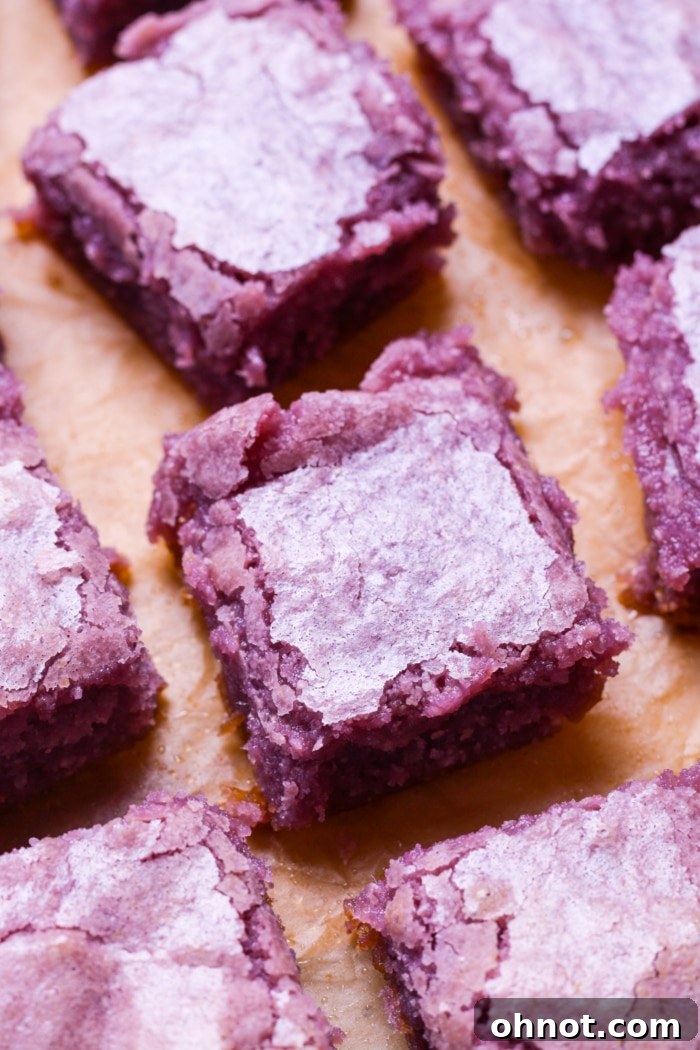 Close-up view of two neatly sliced purple ube brownies, showcasing their soft texture.